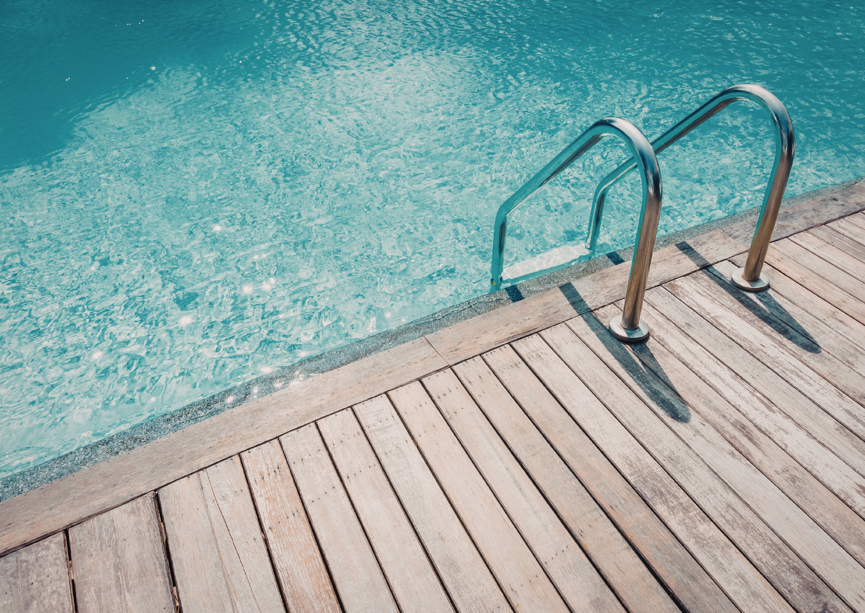 Aménagement extérieur autour de piscine avec terrasse en bois et accès sécurisé
