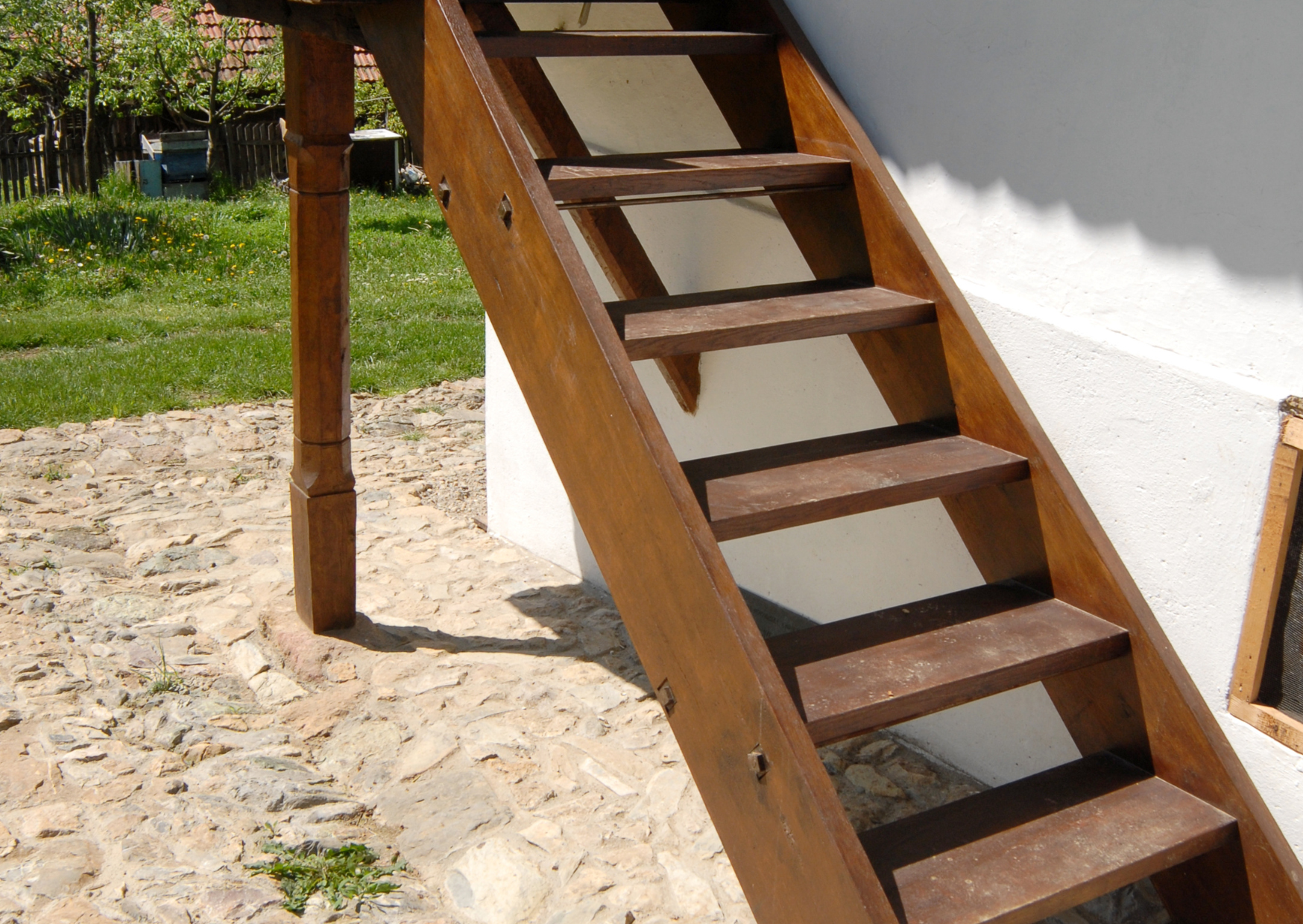 Escalier extérieur en bois permettant l’accès à une terrasse sur terrain en pente