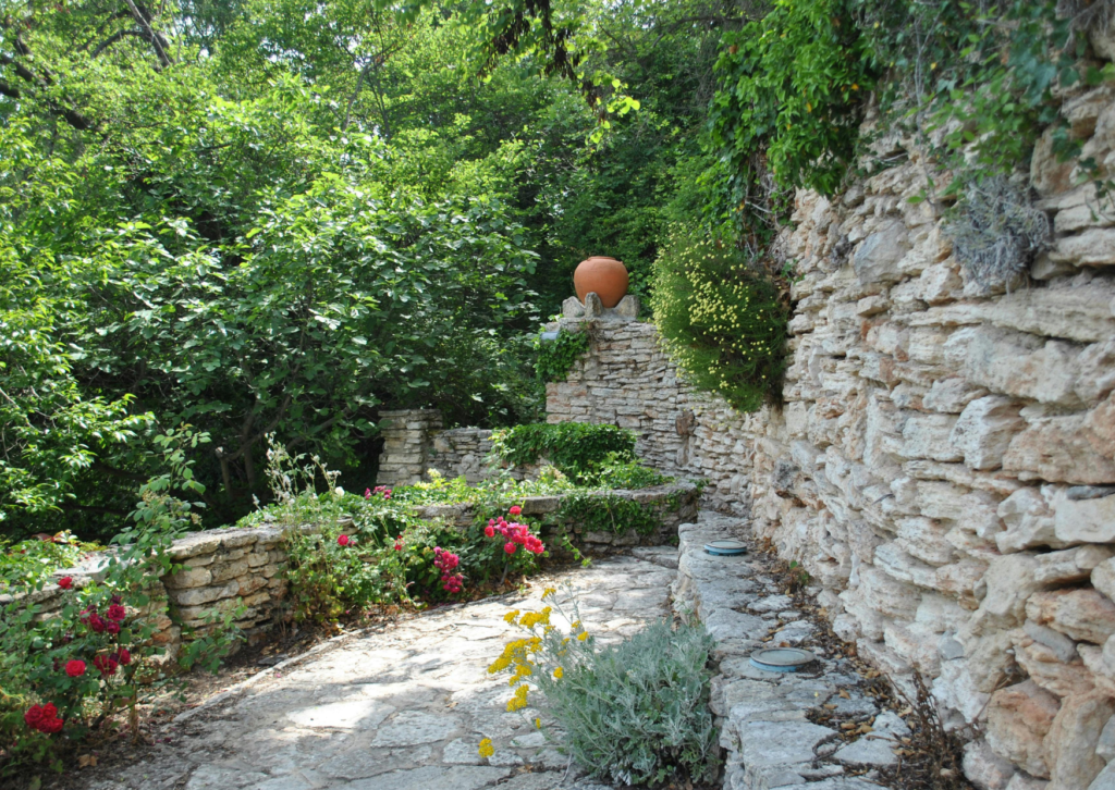 Mur en pierre sèche dans un jardin aménagé avec restanques et plantations en région PACA
