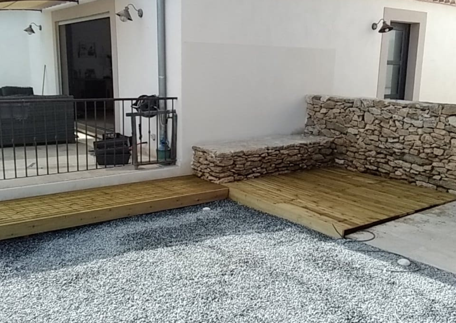 Terrasse en bois avec mur en pierre sèche dans un aménagement extérieur à Aubagne